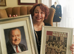 Judi Betts sitting, holding up two frames